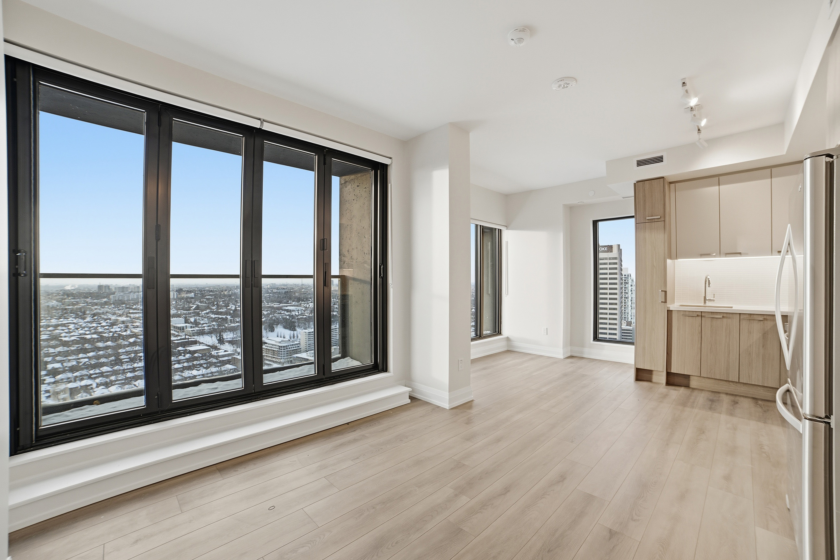 Bright unit with floor-to-ceiling balcony windows and skyline view